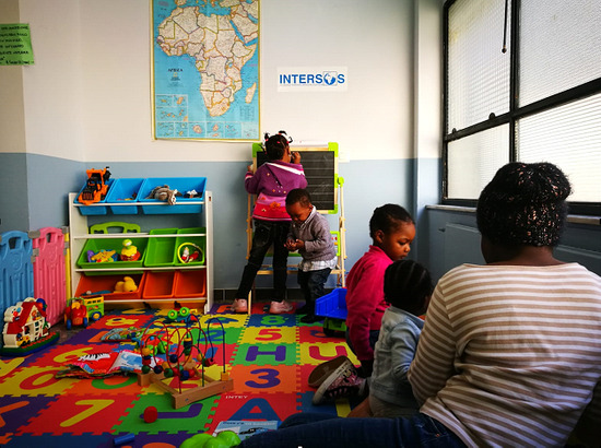 alcuni bambini interagiscono fra loro in un aula allestita per il gioco e la didattica